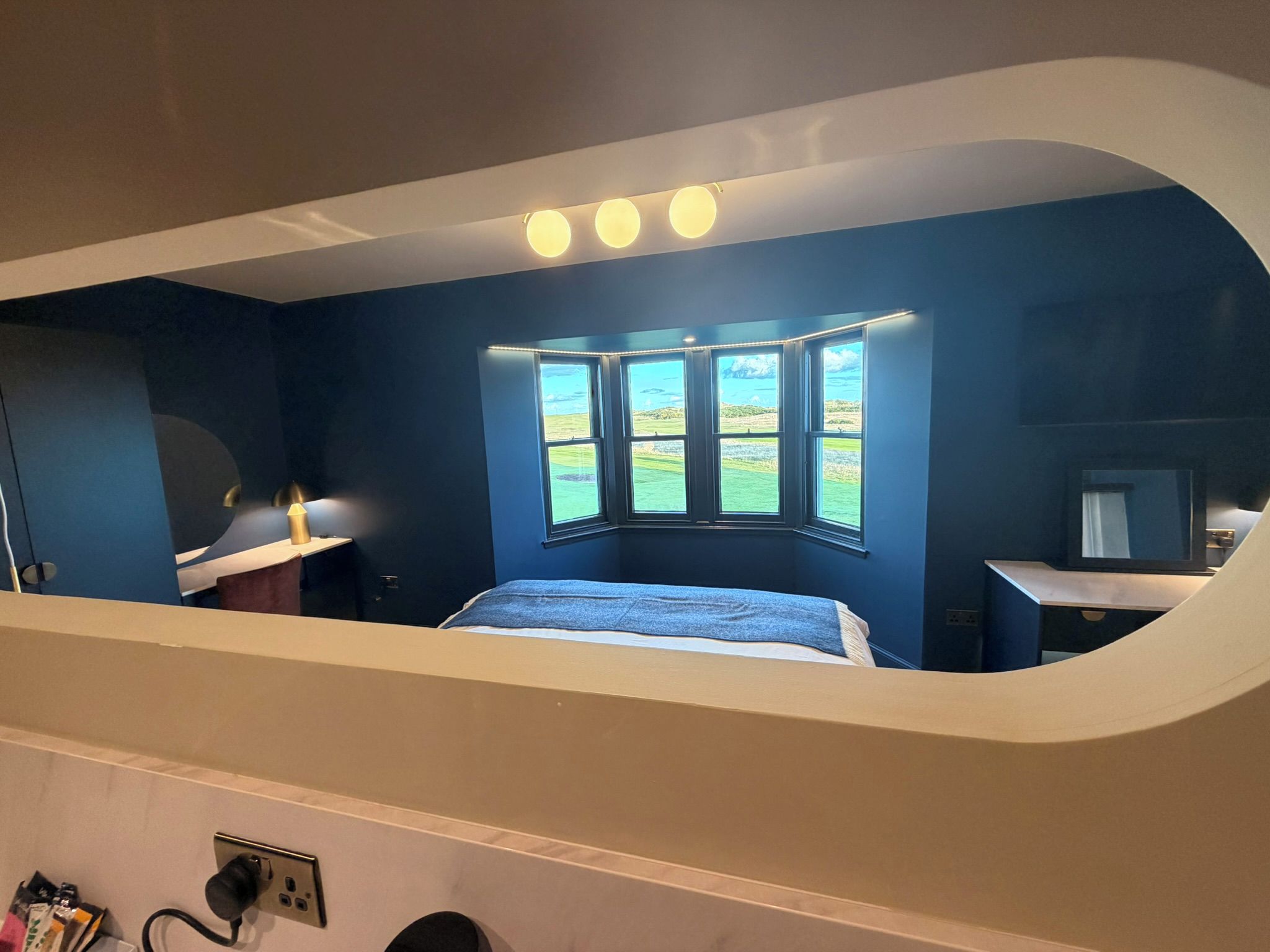 Ein Schlafzimmer mit gewölbter Decke, einem Bett, einem Schreibtisch und Blick ins Freie.