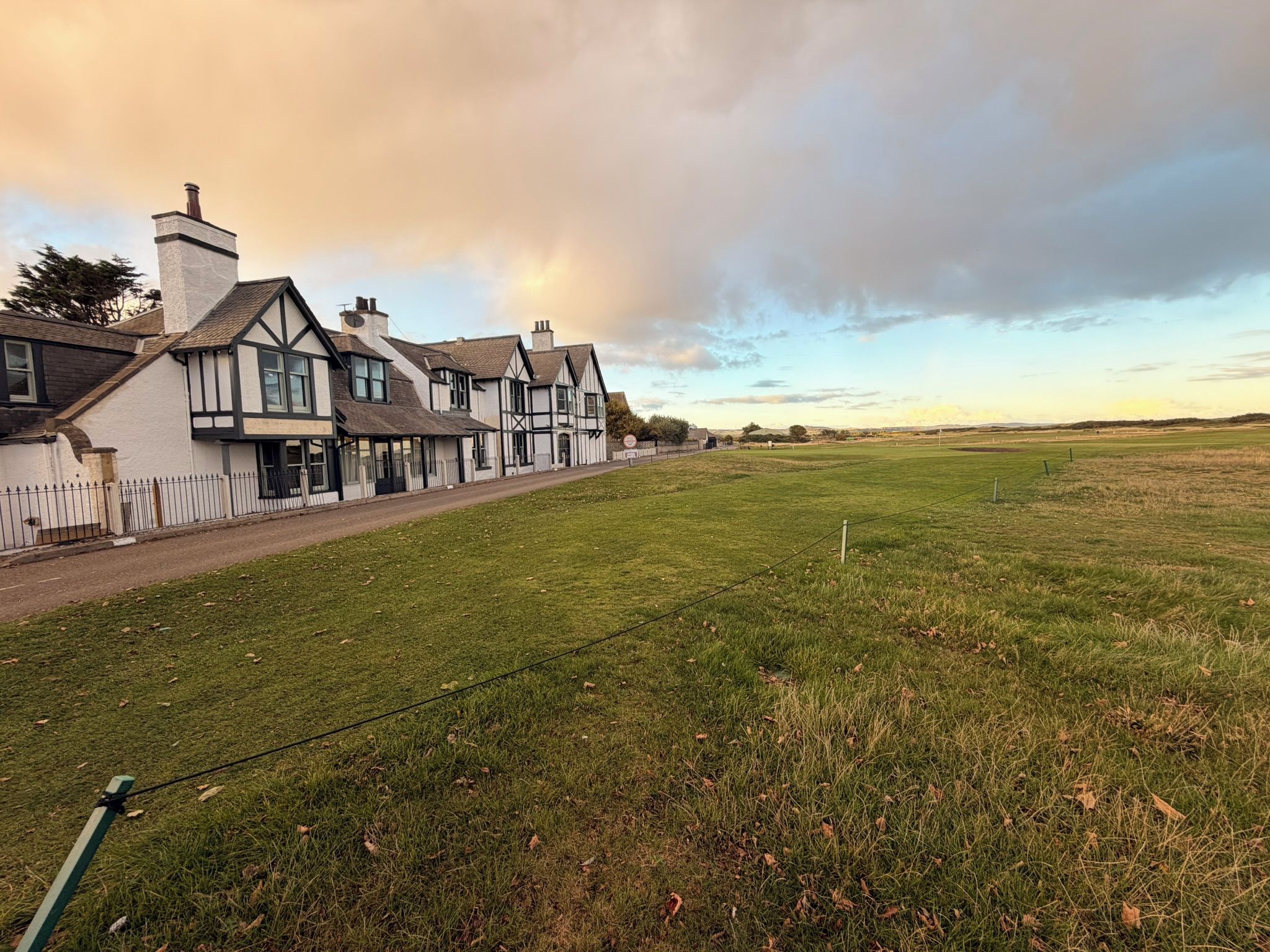 A row of traditional houses with a grassy field in the foreground.