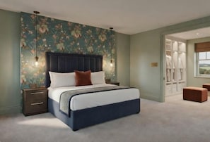 A bedroom with a large bed, a nightstand, a wardrobe, and a window with a view. - The Villa (Montrose)