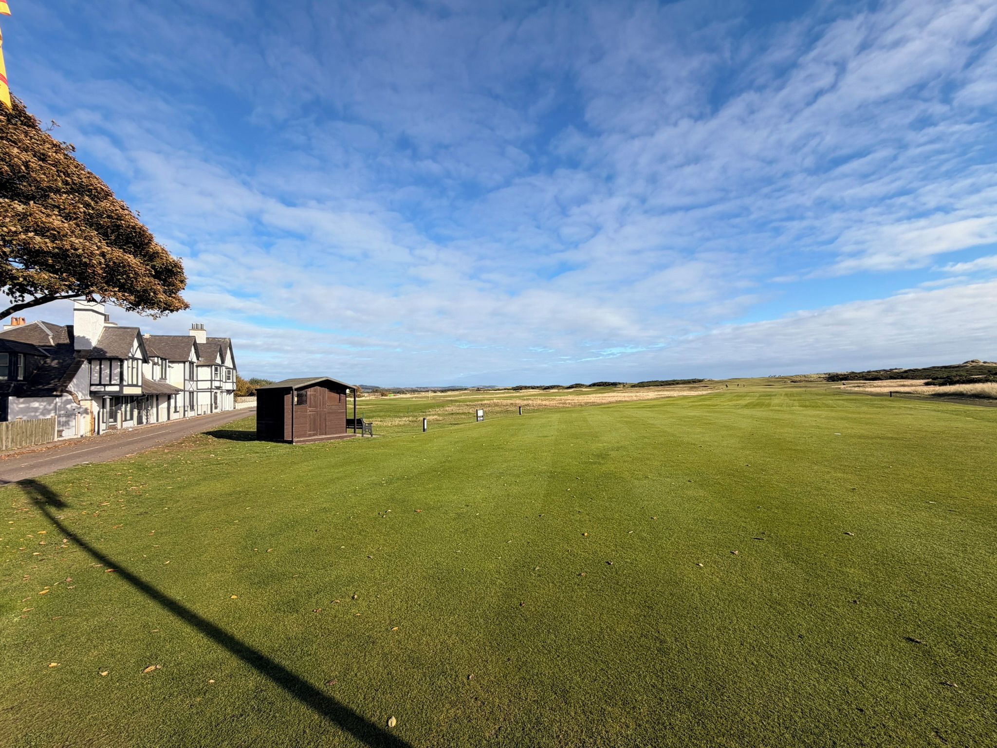 A golf course with a clubhouse and a large open field.