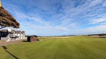 A golf course with a clubhouse and a large open field.