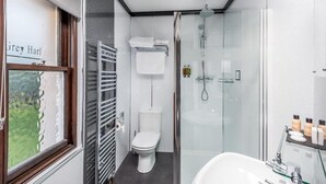 A modern bathroom with a glass shower enclosure, a toilet, and a sink.