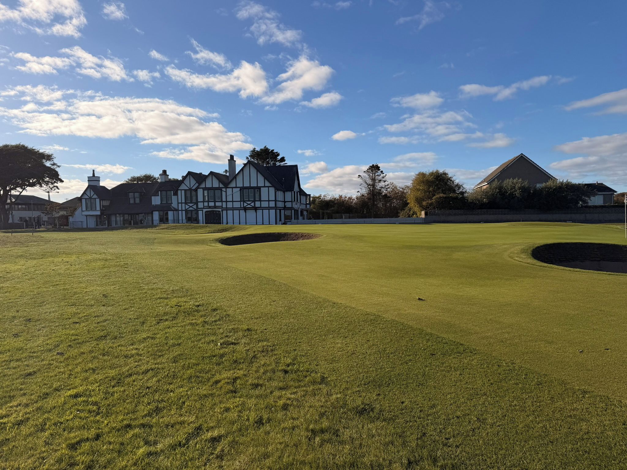 Ein Golfplatz mit Clubhaus im Tudorstil.