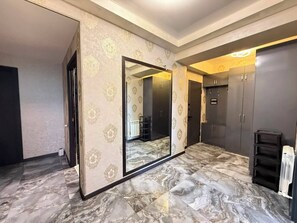 A room with a large mirror, dark cabinets, and a marble floor. - Panoramic Ararat View Apartment (Yerevan)