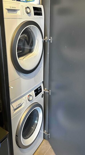 A stacked Bosch washing machine unit with a control panel and a front-loading washer. - Golden Sun Adults-Only Luxury Apartment in Rhodes (Rhodes)