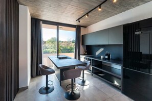 A modern kitchen with a dining area, large windows, and a view of the outdoors. - Golden Sun Adults-Only Luxury Apartment in Rhodes (Rhodes)