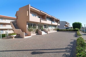 Un hôtel à plusieurs étages, doté d ’un design moderne, comprenant un escalier central, des balcons et une allée pavée.