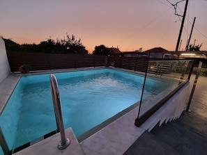 A rectangular swimming pool with a glass barrier and metal railings, surrounded by a concrete deck. - Manolis Seaside Villa with Private Pool, 500m from the Beach (Rhodes)