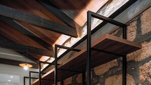 Un pasillo con pared de piedra y estanterías de madera.