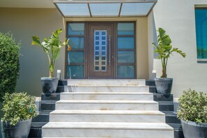 A set of marble steps leading to a door with a glass panel and frosted glass windows. - Crethion | Private Pool, Jacuzzi, Gym & Games Room (Violi Charaki)