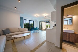 A modern living room with a sofa, coffee table, and dining area. - Crethion | Private Pool, Jacuzzi, Gym & Games Room (Violi Charaki)