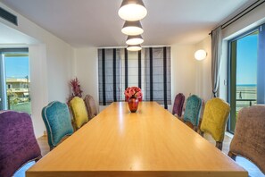 A conference room with a long table and multiple chairs, a vase with flowers, and large windows with curtains. - Crethion | Private Pool, Jacuzzi, Gym & Games Room (Violi Charaki)