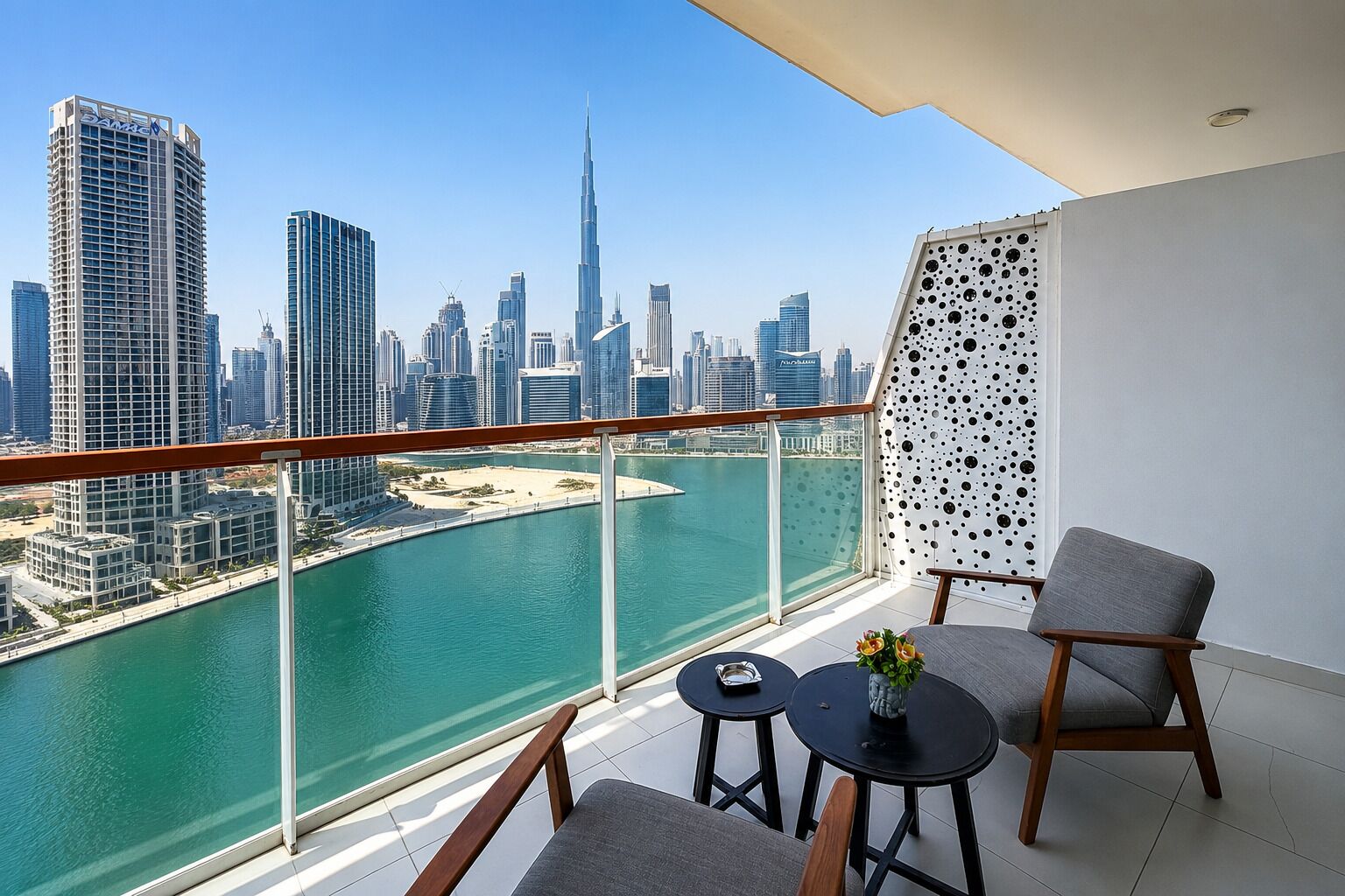 A balcony with a view of a city skyline, a pool, and modern furniture.