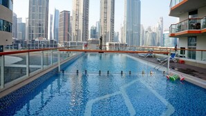 Una piscina sul tetto con una skyline cittadina sullo sfondo.