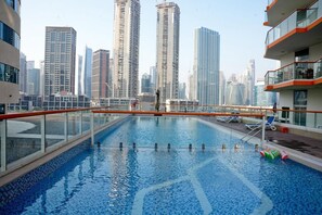 A rooftop swimming pool with a city skyline in the background. - Panoramic Burj Khalifa and Canal View, Business Bay, Dubai, UAE (Dubai)