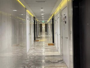 A hotel corridor with mirrored walls, a marble floor, and doors leading to rooms. - Panoramic Burj Khalifa and Canal View, Business Bay, Dubai, UAE (Dubai)