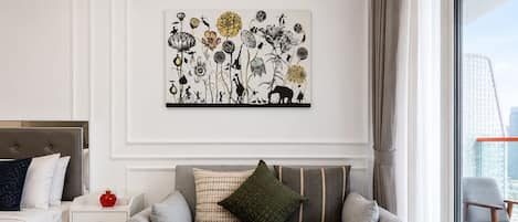 A modern living room with a grey sofa, a small table, and a wall-mounted artwork.