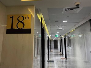 A corridor with a sign indicating the 18th floor, glass doors, and a clean, reflective floor. - Panoramic Burj Khalifa and Canal View, Business Bay, Dubai, UAE (Dubai)