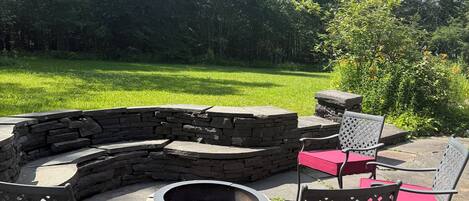A circular stone fire pit with seating around it.
