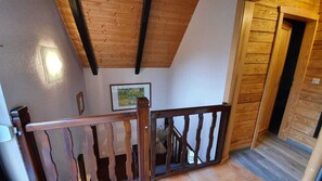 A wooden staircase with a railing, a framed picture on the wall, and a wooden door. - Romantic vacation home nestled in the heart of the Spreewald countryside—pure tranquility (Burg (Spreewald))
