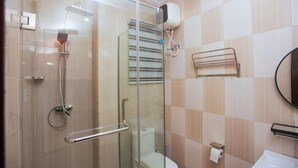 Un bany amb dutxa de vidre, vàter, paraigua de tovalloles i un lavabo.