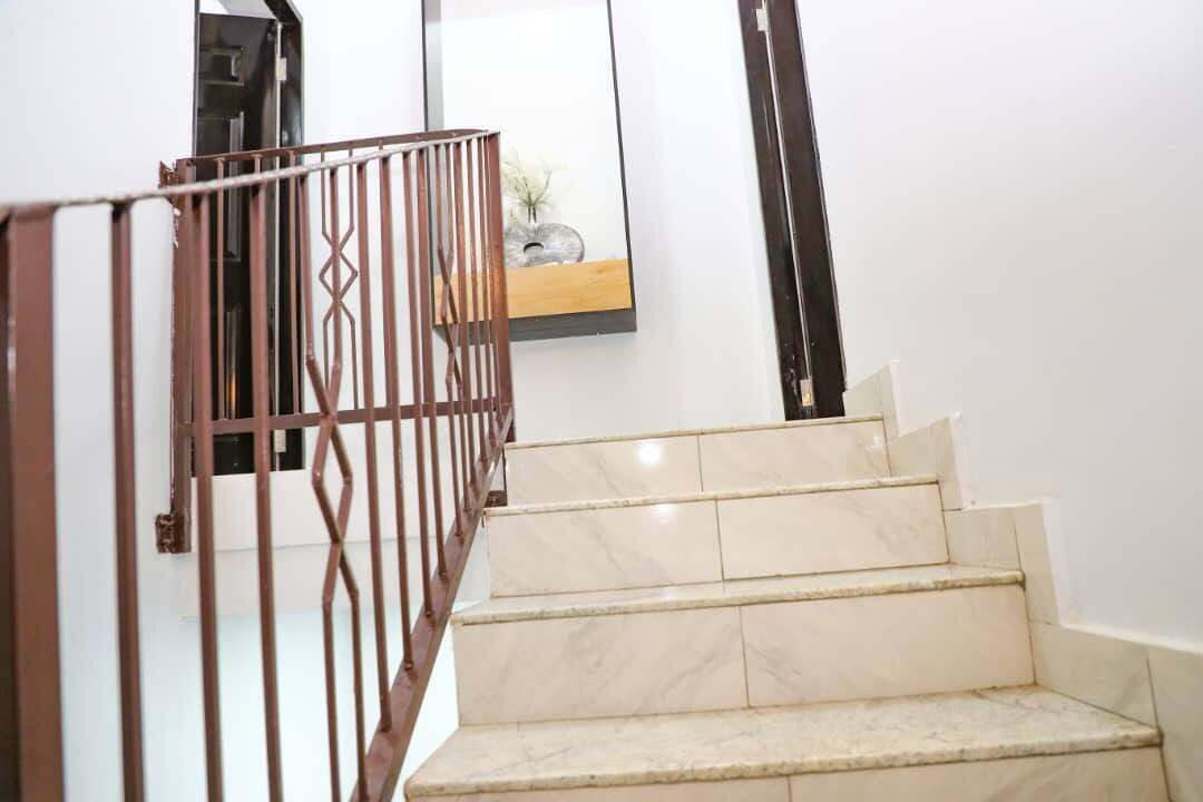 Una scala con gradini in marmo e ringhiera in metallo.