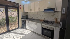 A modern kitchen with a built-in oven, a gas stove, and a dishwasher.