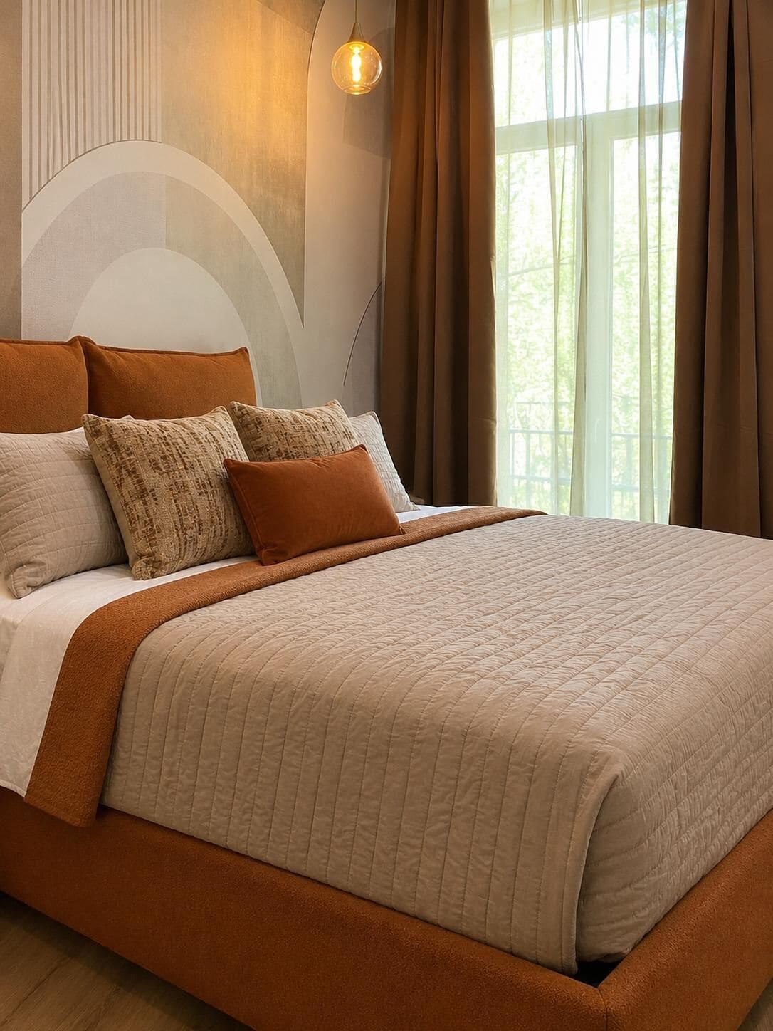 A bed with a quilted cover, multiple pillows, and a headboard.