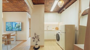A modern kitchen with a washing machine, a sink, and a dining area with a table and chairs. - 5MINS SEOUL STATION-3BR FAMILY STAY WITH PATIO (Seoul)