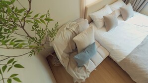 A bedroom with a bed, pillows, a blanket, and a plant. - 5MINS SEOUL STATION-3BR FAMILY STAY WITH PATIO (Seoul)