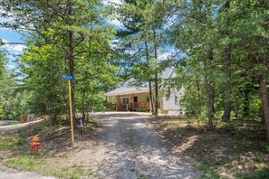 A cabin with a porch, surrounded by trees, and a gravel path leading to it. - Perch&PineEscape, HotTub, Sauna, Firepit, Gameroom! (Basye)