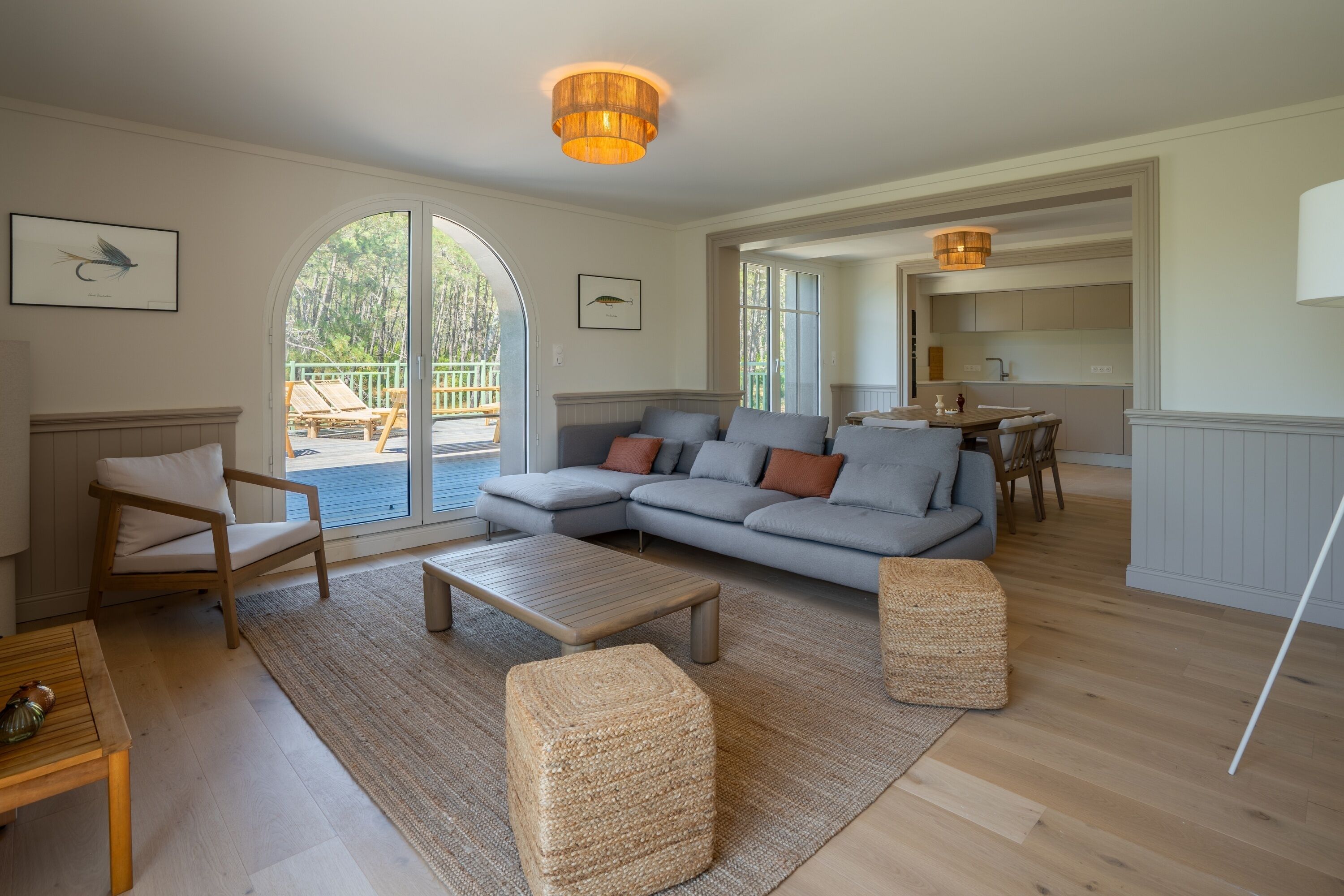 A spacious living room with a large sectional sofa, a wooden coffee table, and a view of a deck through a glass door.