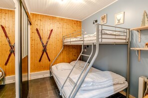 A bunk bed room with wooden walls, a radiator, and a ski rack. - Les Ambrunes - Station de ski accessible à pied (Châtel)