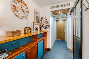 A hallway with a wooden counter, a clock, and various decorative items. - Les Ambrunes - Station de ski accessible à pied (Châtel)