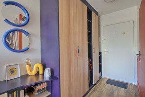 Ein Flur mit einem Holzschrank, einem Spiegel, einem gerahmten Bild und einem kleinen Tisch mit Dekorationen.