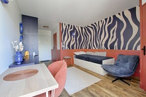 A modern room with a zebra-patterned wall, a bed, a desk, and a chair. - Studio Z - Parc des Expos (Vanves)