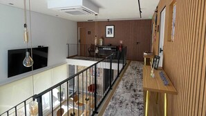 Un interior modern amb una escala, una zona de menjador i una cuina.