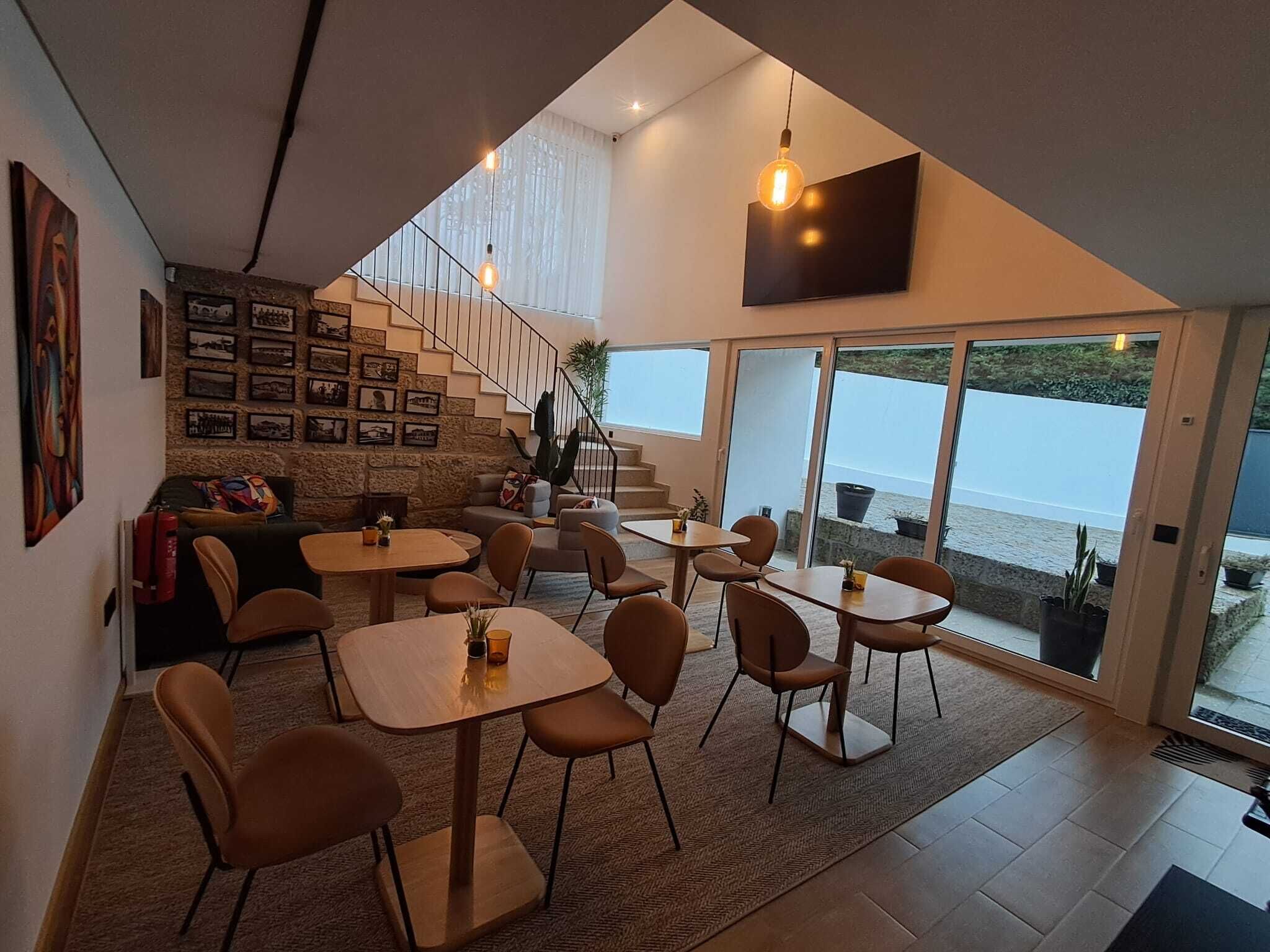 Un intérieur moderne avec un escalier, un coin repas et de grandes portes-fenêtres coulissantes donnant sur un balcon avec vue.