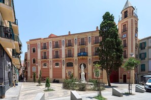 Ein Gebäude mit Innenhof, einer Statue und einem Glockenturm.