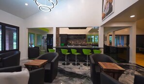 A modern interior with a bar area, green bar stools, and a kitchen in the background. - Spacious private Oasis (Los Angeles)