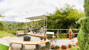 An outdoor patio with a wooden deck, a barbecue grill, and seating areas. - Nomad Nest Near Guatapé Jacuzzi Turkish Wifi-full (El Peñol)