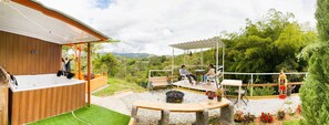An outdoor patio with a wooden deck, a barbecue grill, and seating areas. - Nomad Nest Near Guatapé Jacuzzi Turkish Wifi-full (El Peñol)