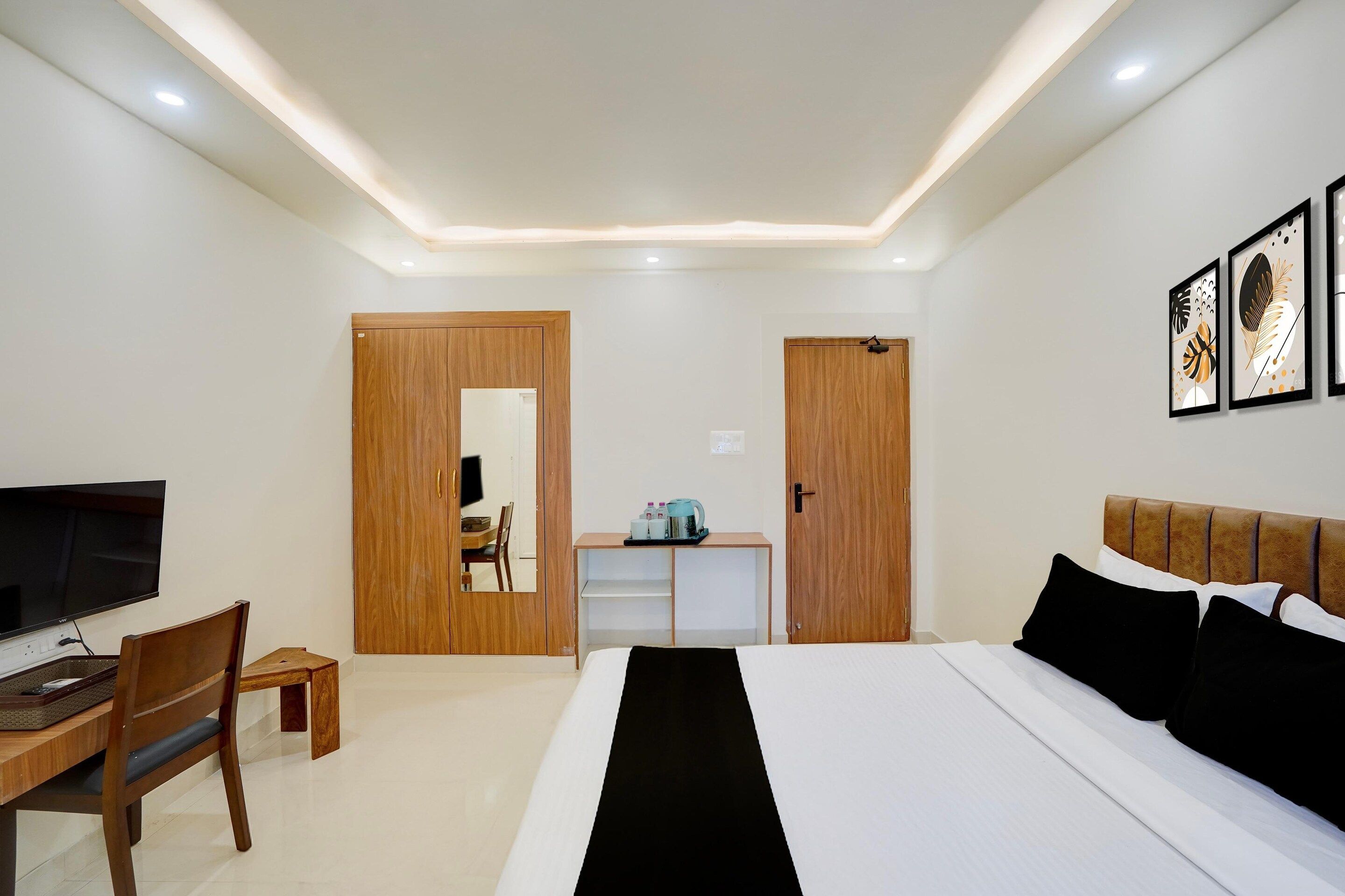 Une chambre d’hôtel équipée d’un lit, d’un bureau, d’une télévision et d’une armoire.