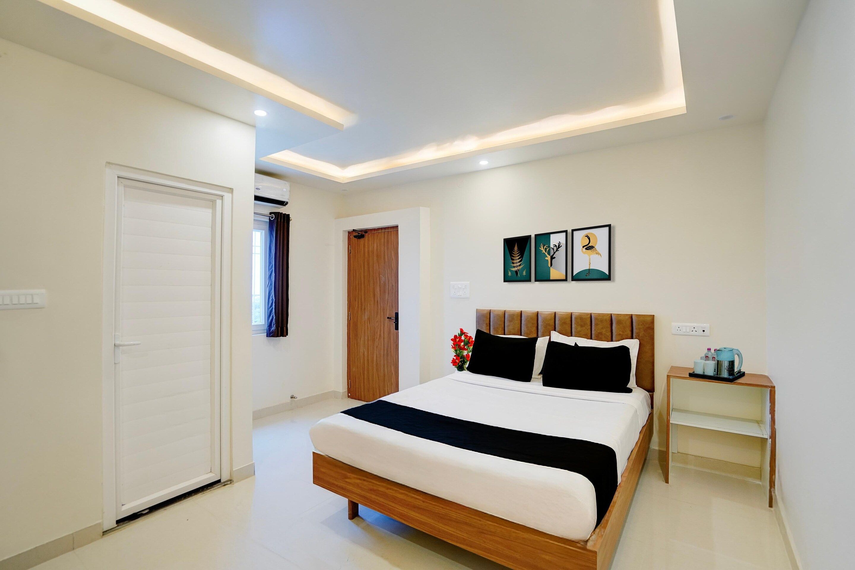 A hotel room with a bed, bedside table, and artwork on the wall.