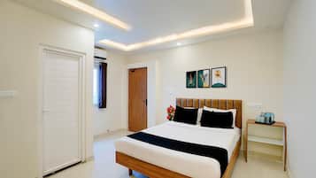 A hotel room with a bed, bedside table, and artwork on the wall.