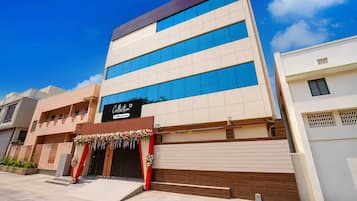 Un edificio de varios pisos con un diseño arquitectónico moderno, que presenta una entrada destacada con un letrero que dice 'Collection' y 'Oyo-Serviced'.