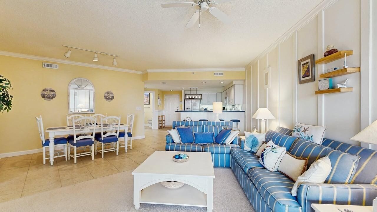 A living room with a sofa, chairs, a coffee table, and a dining area with a table and chairs.