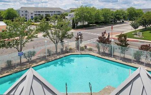 A swimming pool with a white fence, surrounded by trees and a parking lot. - Lorelei II 405 - Your perfect Ocean City getaway! (Ocean City)