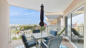 Ein Balkon mit Tisch, Stühlen und einem Sonnenschirm, sowie amerikanische Flaggen.