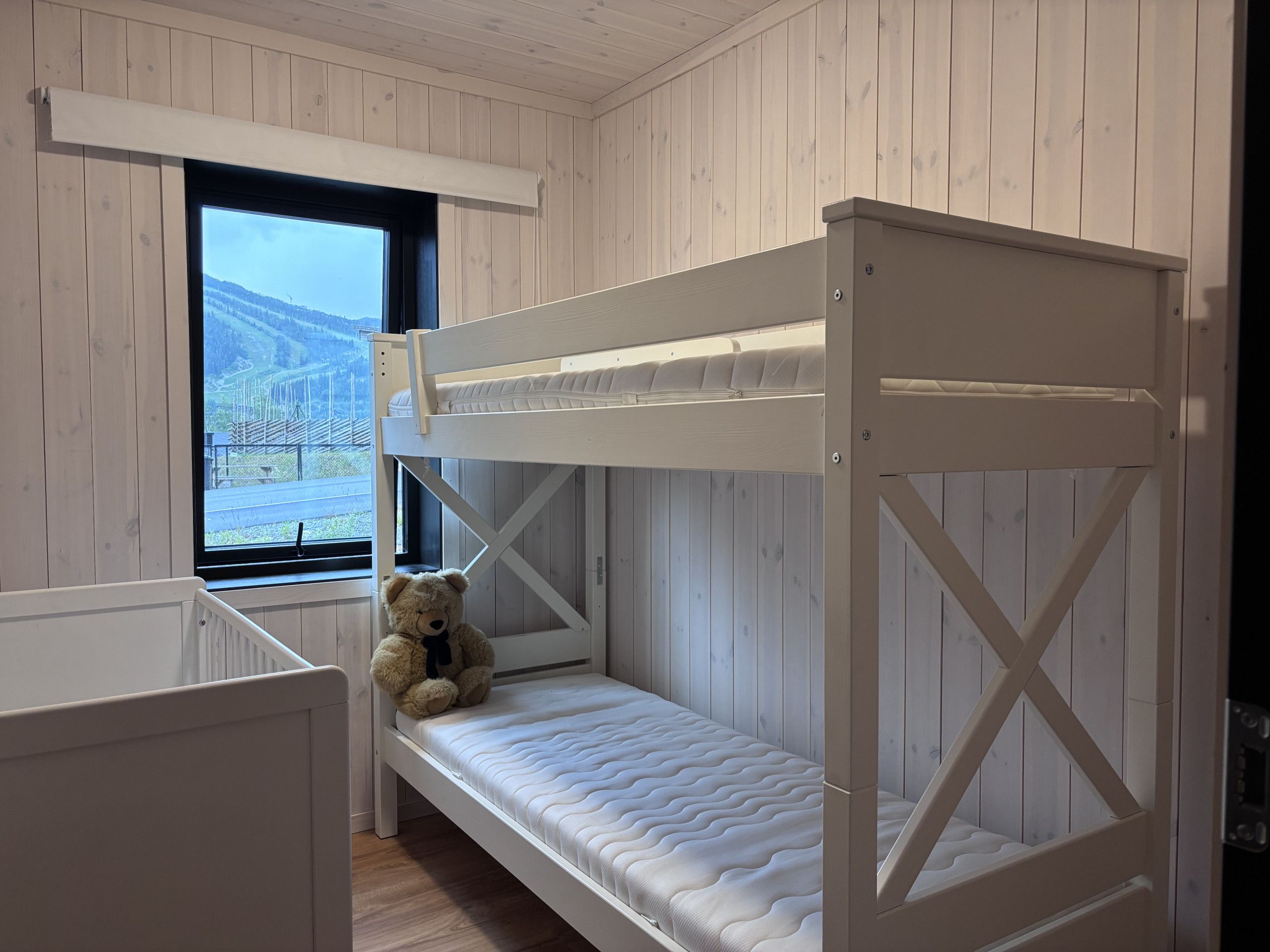 Un lit superposé avec un matelas et un ours en peluche sur le lit du bas.